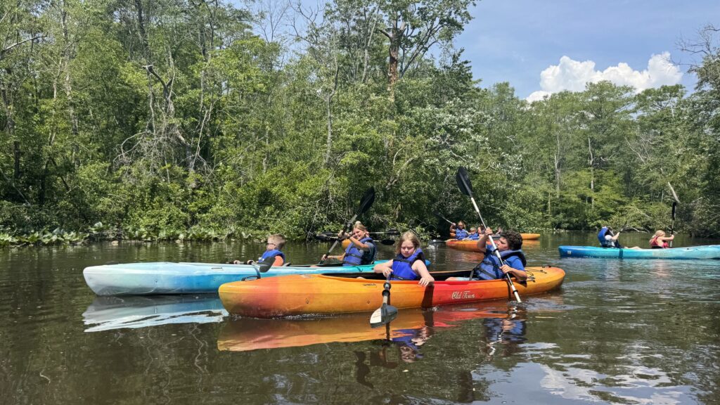 children in canoes on a river